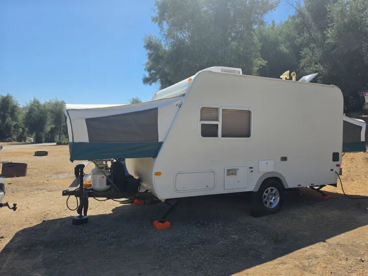 RV rental: A white pop-up travel trailer, fully set up at a sunny campsite, with amenities visible.. R-Vision Trail-Lite Bantam 2002