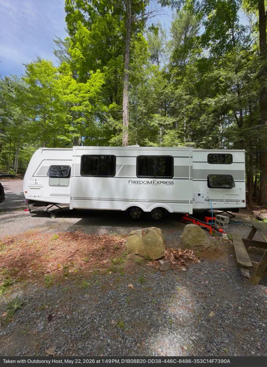 Enjoy nature with this white Coachmen Freedom Express rv rental, parked in a shady, wooded campsite.. Coachmen 29 SE 2025
