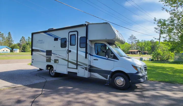 This Coachmen Prism Class C RV rental is parked on a sunny day, with power cord connected, ready for adventure!. Forest River Coachmen Prism 2018