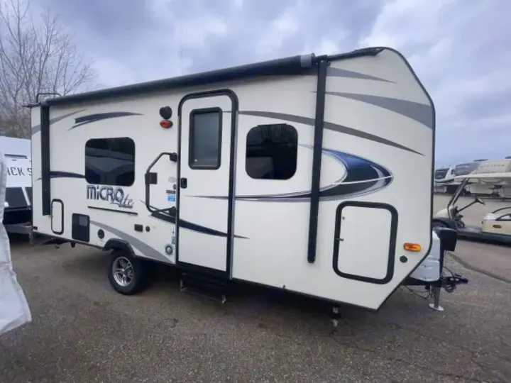 Micro Lite travel trailer for rv rental, featuring an awning & sleek design, parked outside.. Forest River Flagstaff Micro Lite XLT 2017