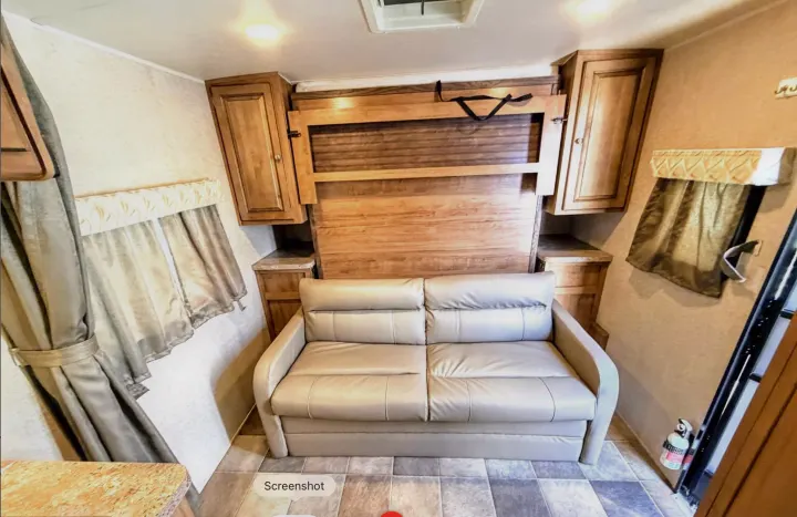 Explore this RV rental's versatile living space: a comfortable sofa, convertible murphy bed, and ample storage.. Forest River Flagstaff Micro Lite XLT 2017