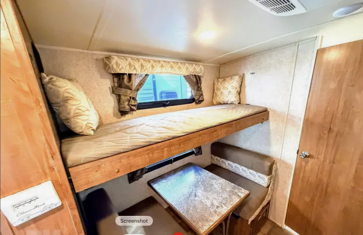 Cozy RV rental interior with bunk bed, dinette, and window, perfect for your next road trip adventure.. Forest River Flagstaff Micro Lite XLT 2017