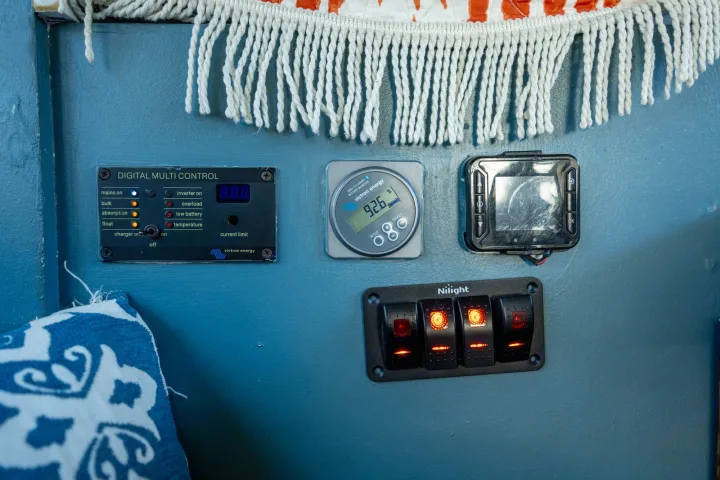 RV rental control panels: Victron Energy digital multi control, battery monitor (92.6%), and illuminated Nilight rocker switches manage power.. Chevrolet Express s3500 2003