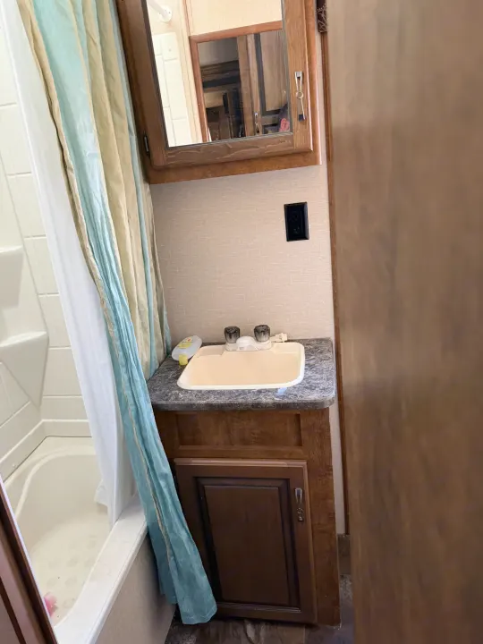 RV rental bathroom with shower, sink vanity, and medicine cabinet, showcasing a functional small space.. Crossroads RV Rezerve 2015
