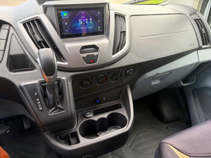 Inside an **rv rental**, this **vehicle interior** features a JVC **infotainment screen** (showing May 29, 2026), **gear shifter**, and **dashboard controls**.. FORD TRANSIT 250 2015