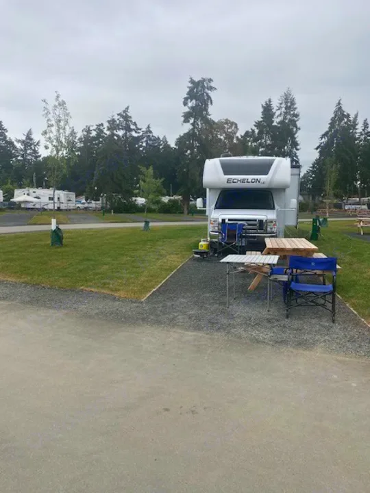 An Echelon RV rental parked at a campground site, complete with a picnic table and chairs for outdoor relaxation.. Thor Echelon 2022