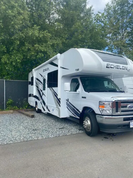 White Echelon LC Class C RV rental parked on gravel, ready for adventure. This clean, modern motorhome is ideal for travel.. Thor Echelon 2022
