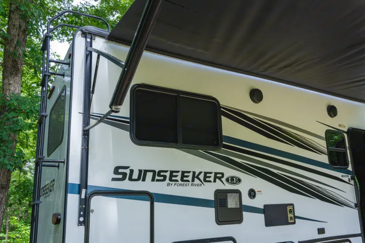 Sunseeker by Forest River RV rental, side view with extended awning & bright LED lights. Perfect for camping trips.. Forest River Sunseeker LE 2024