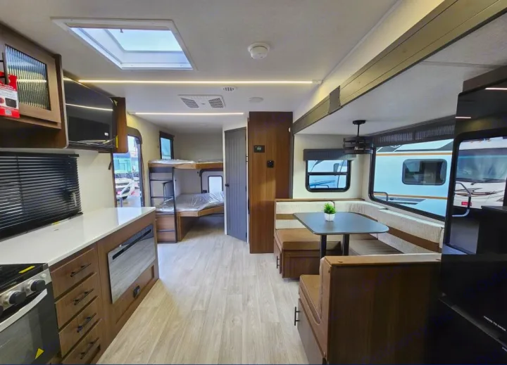 Bright RV rental interior featuring a modern kitchen, U-shaped dinette, and bunk beds, perfect for family trips.. Forest River 246DBX 2026