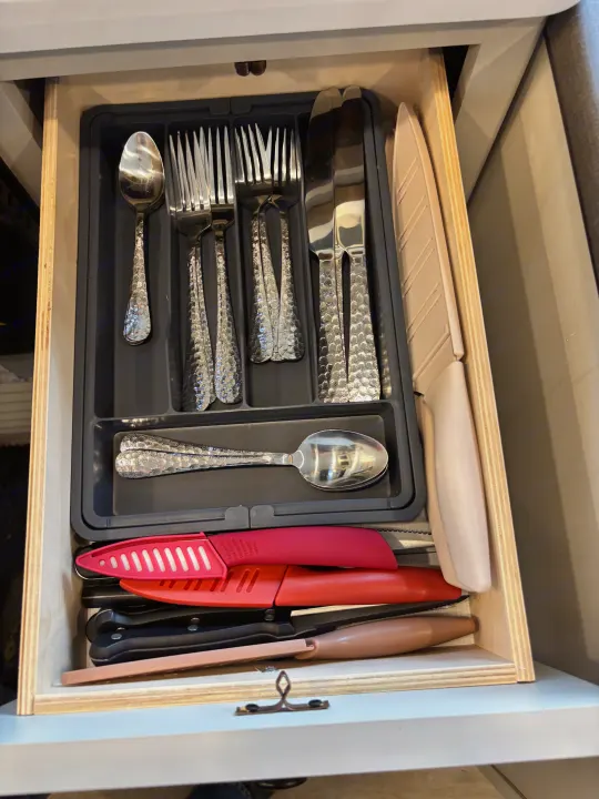 RV rental drawer: Organized kitchen cutlery, featuring textured silverware and safely sheathed knives for your journey.. Forest River Coachmen Northern Spirit Ultra Lite 2026