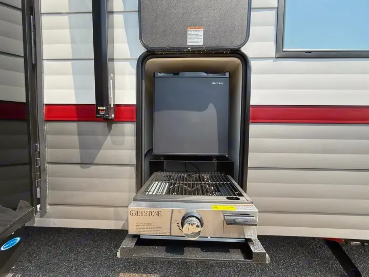 This RV rental features a convenient outdoor kitchen with a pull-out Greystone grill and a Contoure mini-fridge.. Forest River Campsite Reserve 2026