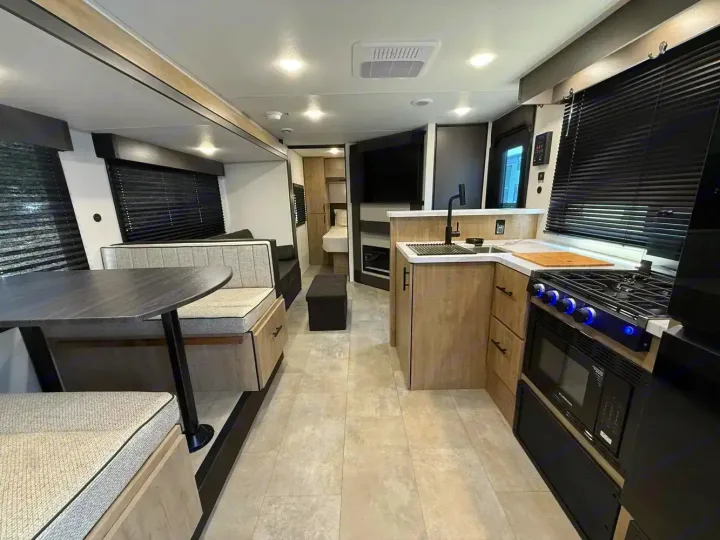 Spacious RV rental interior featuring a full kitchen, comfortable dinette, and private bedroom area for your next adventure.. Forest River Campsite Reserve 2026