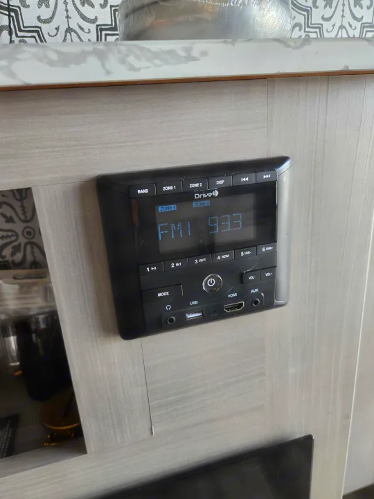 Drive RV rental audio control panel displays FM 93.3, with USB, HDMI, AUX inputs for traveler entertainment.. Dutchmen Coleman Lantern 2022