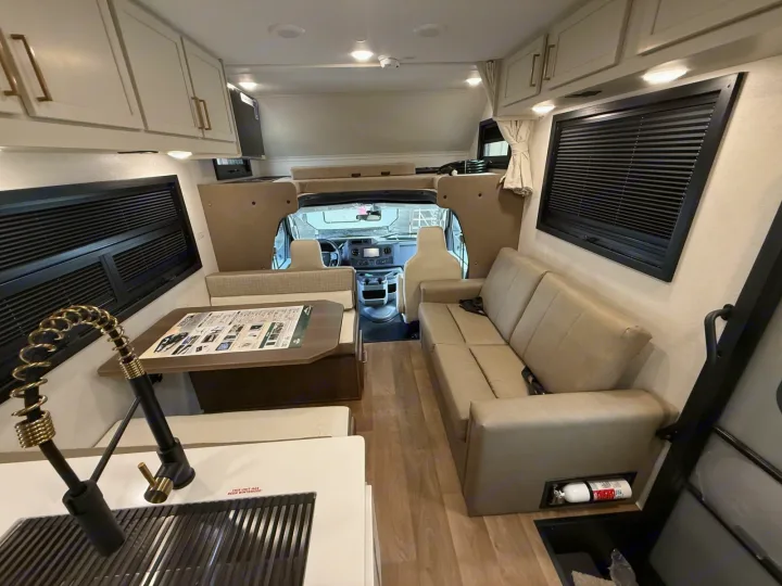 Spacious RV rental interior featuring a kitchen, dinette, sofa, and overhead bunk area, ready for adventure.. 2027