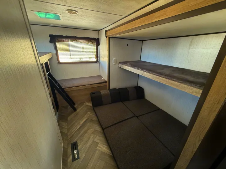 RV rental bunk room: multiple sleeping options including fixed bunk beds, a lower bed with ladder, and a convertible sofa.. Heartland RVs Prowler 2022