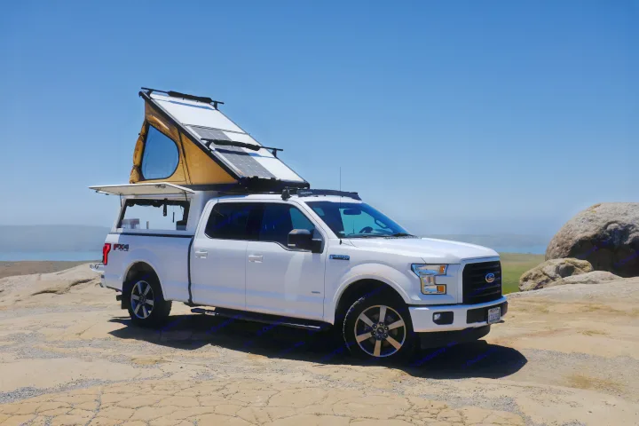 This white Ford F-150 pickup, equipped with a pop-up tent & solar panels, is an ideal RV rental for scenic coastal exploration.. Ford Ford F150 2017