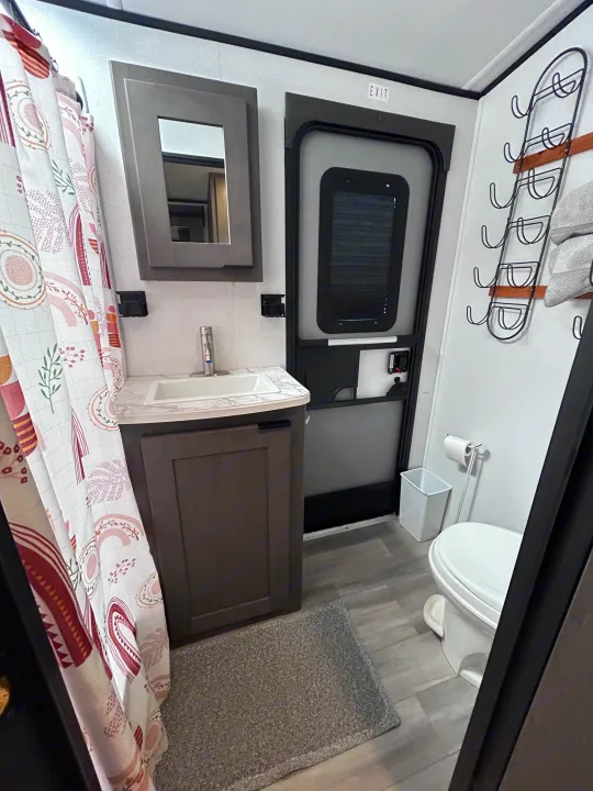 RV rental bathroom featuring a shower with a decorative curtain, vanity with sink, toilet, and towel rack.. Cruiser RV MPG Ultra Lite 2021