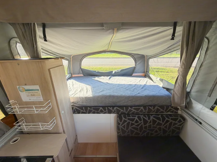 Step inside this cozy rv rental pop-top camper. A comfortable bed with patterned comforter & large windows for scenic views.. Outback Eagle Off-Road 2015