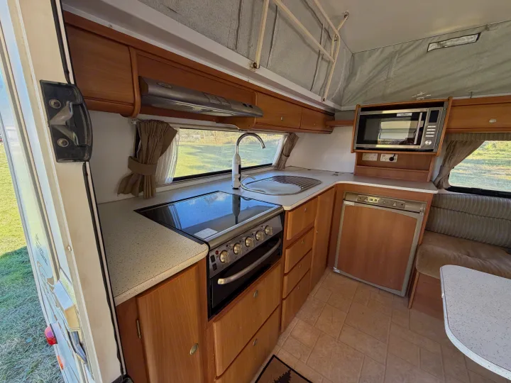 Inside this RV rental, a compact yet modern kitchen offers a stove, sink, microwave, fridge, and dining space for your journey.. Jayco J Series 2008