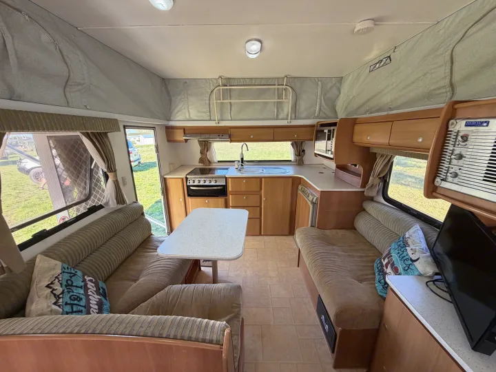 Inside an RV rental, discover a functional kitchen with oven, sink, microwave, and a cozy dinette. Perfect for road trips.. Jayco J Series 2008