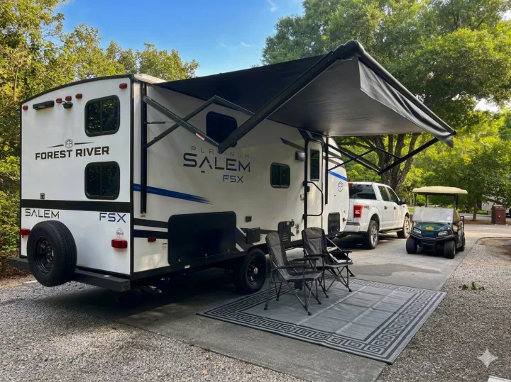 Forest River Salem FSX RV rental at a campsite, with an extended awning, chairs, truck, and golf cart ready.. Forest River Salem FSX 2025
