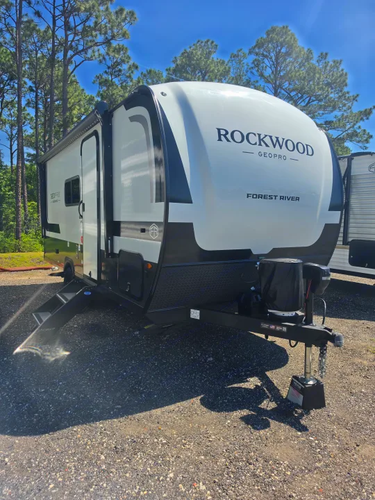 White & black Rockwood GeoPro travel trailer for rv rental. Ready for camping adventures amidst tall pine trees.. Forest River Rockwood Geo Pro 2026