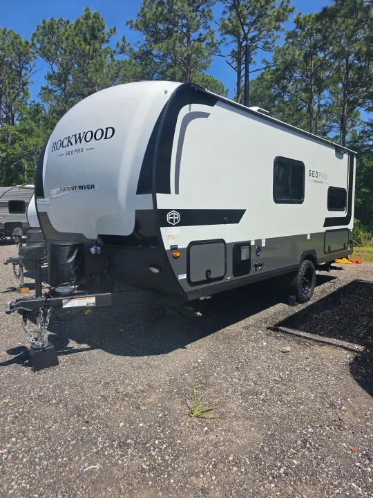 White and black Rockwood Geo Pro travel trailer, available for rv rental. Parked on a gravel lot under sunny skies.. Forest River Rockwood Geo Pro 2026