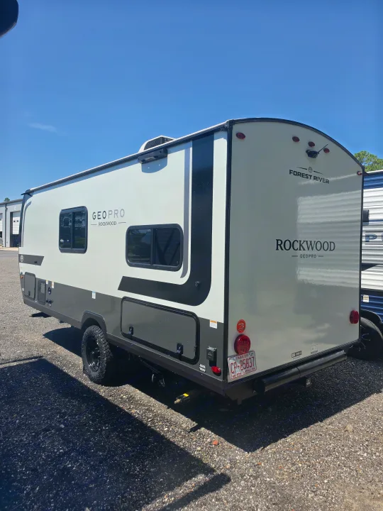 A compact white and grey Forest River Rockwood Geo Pro travel trailer, perfect for an RV rental adventure with off-road tires.. Forest River Rockwood Geo Pro 2026