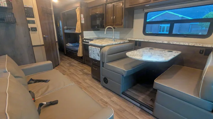 Spacious RV rental interior with kitchen, dinette, sofa, and bunk beds. Perfect for family travel!. Jayco Alante 2020
