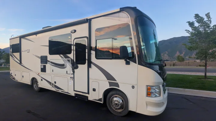 White & black Jayco Alante Class A RV rental parked outdoors. Scenic mountain backdrop for your next motorhome adventure.. Jayco Alante 2020
