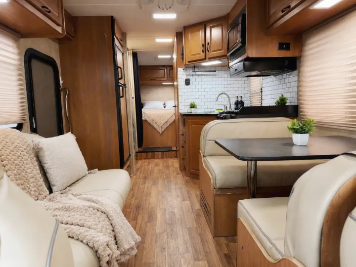 Spacious RV rental interior with a cozy sofa, dinette, full kitchen, and bedroom, ideal for your next travel adventure.. Thor Majestic 2014
