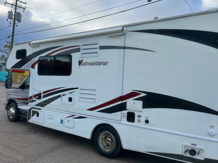 White Adventurer Class C **rv rental** with bold black and maroon graphics, ready for your road trip or camping adventure.. Adventurer Adventurer Motorhome 2016