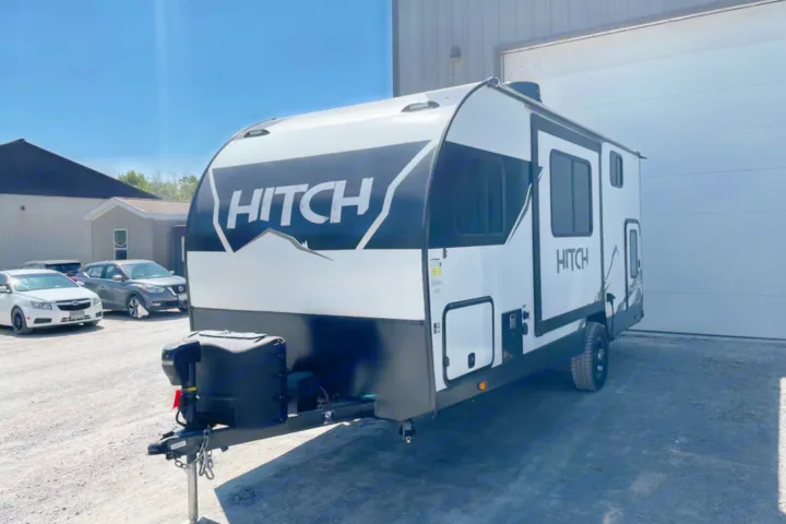 This sleek white and black HITCH travel trailer is ready for your next rv rental adventure, parked outdoors.. Cruiser RV Hitch 2022
