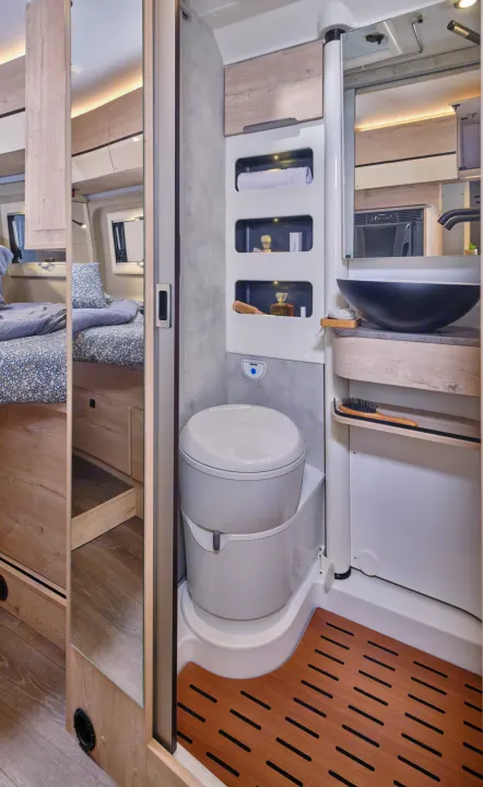 Compact RV rental bathroom showing a toilet, sink, shower, and a reflected view of the cozy bedroom area.. FLORIUM BLACK PEARL 63 LJ 2025