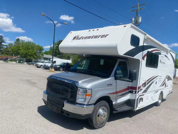 Silver and white Adventurer Class C RV rental, parked outdoors under a blue sky, perfect for your next road trip adventure.. Adventurer Adventurer Motorhome 2016
