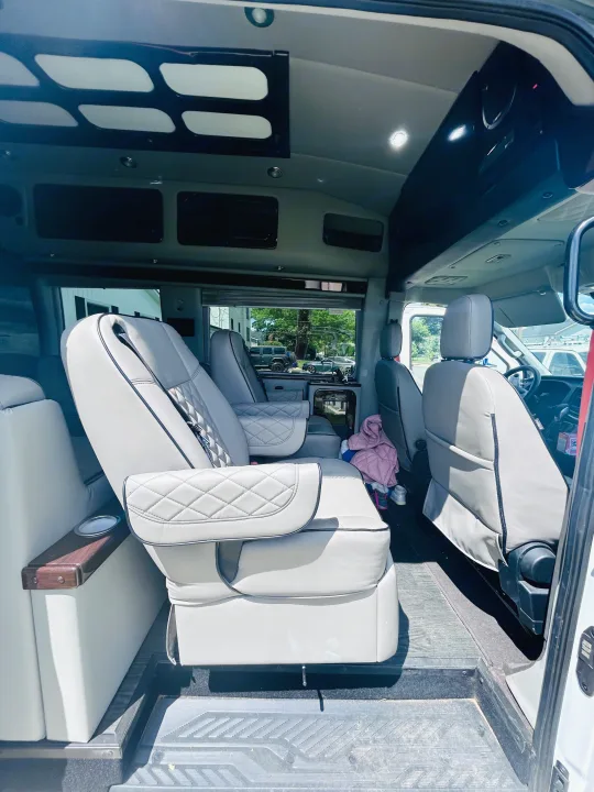 Spacious rv rental interior with luxurious grey captain's chairs, overhead storage, and bright lighting for comfortable travel.. Primetime Avenger 2021