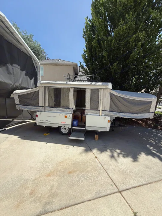 This Coleman Carmel pop-up RV rental is fully set up in a driveway, ready for your next outdoor adventure.. Coleman Grand Tour 2003