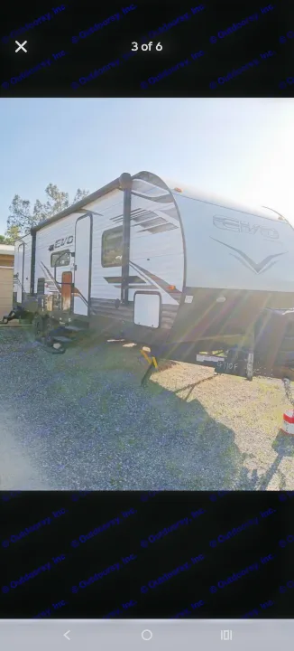 White & brown EVO travel trailer RV rental. Parked on gravel, ready for your next outdoor adventure!. Forest River EVO T2850 2022