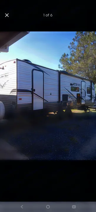 A white and grey EVO travel trailer, perfect for your RV rental adventure. Parked on gravel under a clear sky.. Forest River EVO T2850 2022