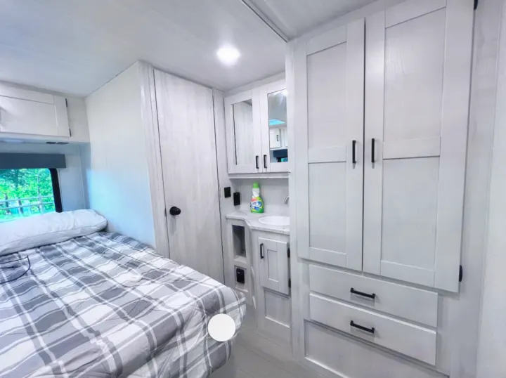 RV rental interior featuring a modern bedroom, compact vanity, and ample storage solutions for comfortable travel.. East to West Entrada 2026