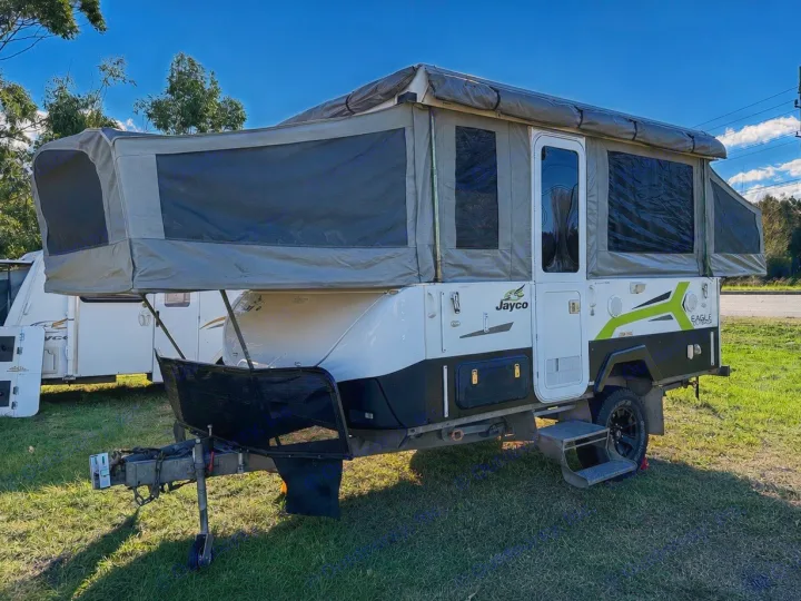 Ready for adventure! A white & black Jayco Eagle Outback pop-up camper, perfect for rv rental. Canvas sections extended, parked on grass.. Outback Eagle Off-Road 2015