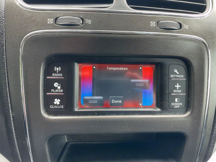 RV rental interior showing an infotainment screen set to climate control temperature. Buttons for radio, media, and settings are present.. Dodge Journey 2016