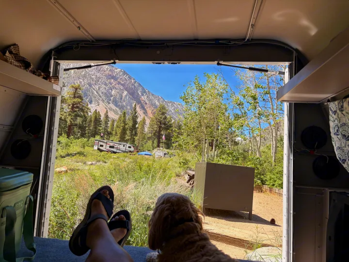 Relaxing inside an RV rental with a dog, feet up, overlooking stunning mountains and a campground with other campers.. Ford Ford F150 2017