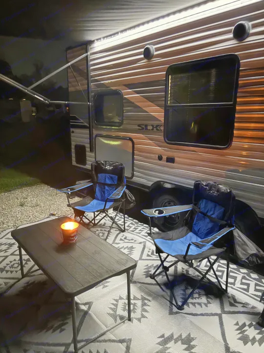 Cozy RV rental setup at night with chairs, table, and candle under awning lights, perfect for relaxing.. Jayco 2026 Jayco Jay Flight SLX 260BH 2026