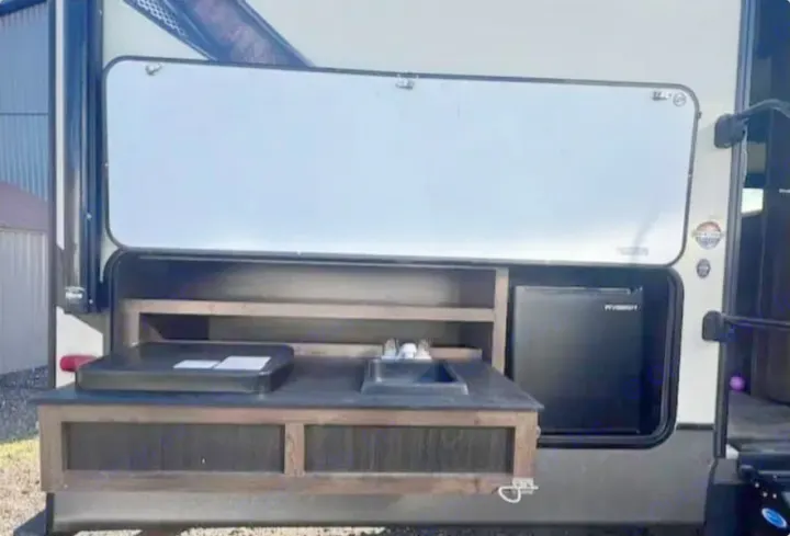 RV rental with a convenient outdoor kitchen featuring a sink, griddle, shelves, and mini-fridge for camping fun.. Crossroads RV Volante 2019