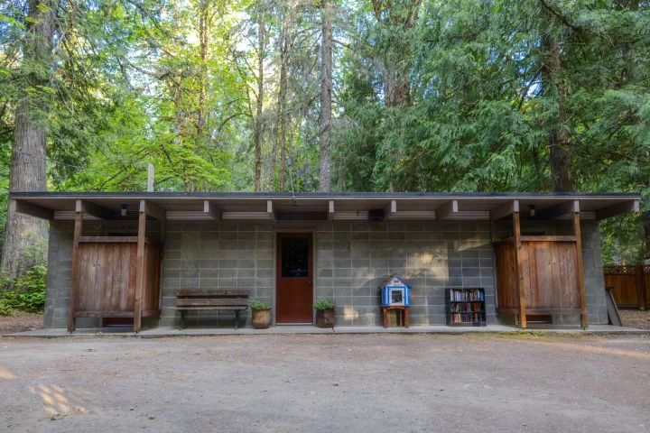 RV rental friendly campground: concrete building with outdoor showers, restroom, and Little Free Library. Set among tall trees.. Crossroads RV Sunset Trail Super Lite 2022