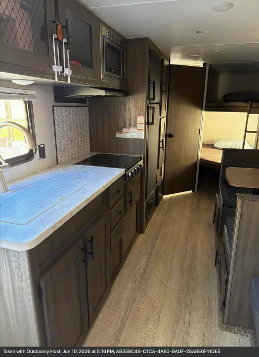 This RV rental interior offers a full kitchen, dinette, and bunk beds, perfect for comfortable travel and family adventures.. Forest River Shasta 2021