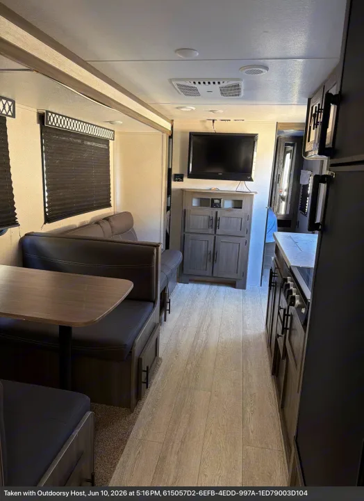 RV rental interior: cozy dinette, entertainment center with TV, and kitchen with modern wood-look finishes.. Forest River Shasta 2021
