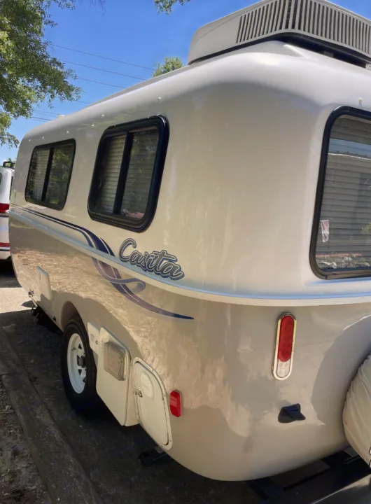 Side view of a white Casita travel trailer with an AC unit and windows, ideal for an rv rental camping trip.. Casita Freedom 2024