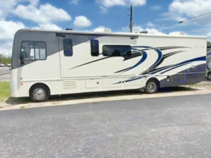 Experience the open road with this spacious white and grey RV rental, featuring blue swirl graphics, parked on asphalt.. Fleetwood FLAIR 2020